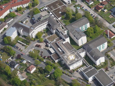 Luftaufnahme des Medinos Klinikums Sonneberg in Thüringen mit den Klinikgebäuden, dem Hubschrauberlandeplatz, Zufahrtswegen und den umliegenden Grünflächen.  Foto: Till Münzberg | Pilot: Martin Münzberg